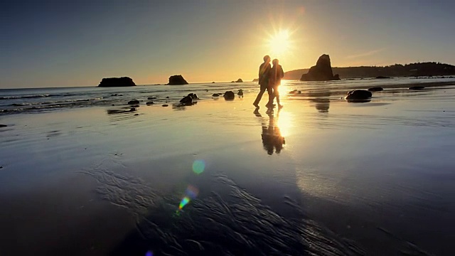 俄勒冈州，一对老年夫妇在日落海滩上散步视频下载