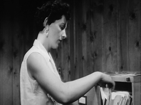1957年B/W特写女人在办公室的文件柜里查看文件视频素材