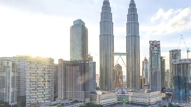 4k的延时镜头。马来西亚国家石油公司双子塔周围的吉隆坡城市天际线日夜日落。缩小视频素材