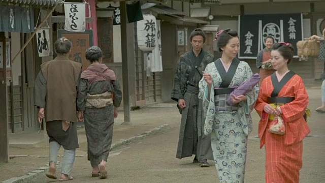 人们穿着传统的日本服装走在日本复古的小镇上。视频下载