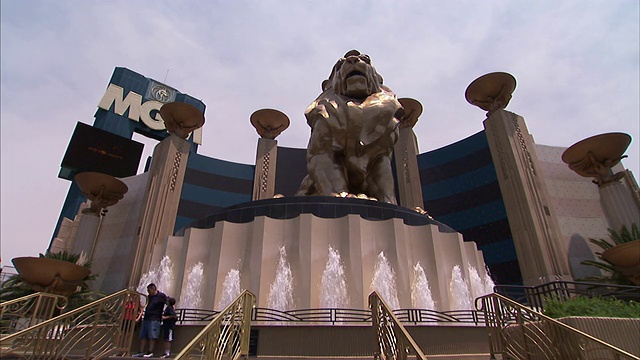 在内华达州拉斯维加斯的米高梅大酒店和赌场前，喷泉围绕着狮子狮子的雕像。视频素材