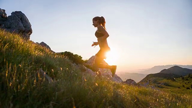 年轻的女运动员在日落时跑上山视频素材