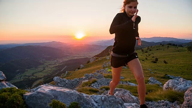 年轻的女性跑步者在岩石上奔跑视频素材
