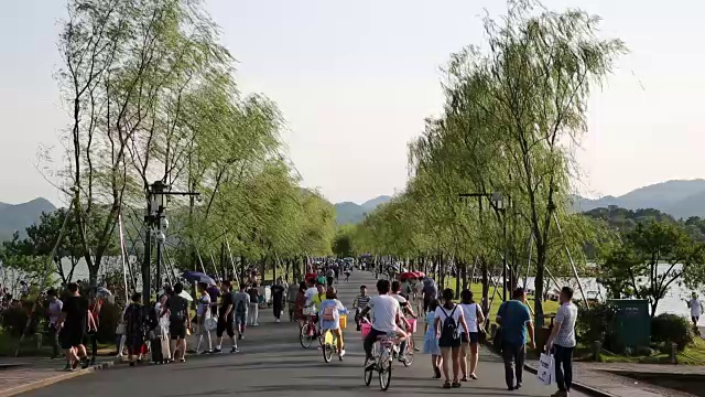 人们走在西湖上的白堤上，中国杭州视频下载
