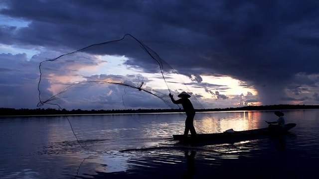 清晨日出前，亞洲漁民在木船上撒網捕魚視頻下載