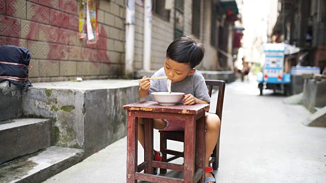 快乐的亚洲孩子用筷子吃美味的面条视频素材