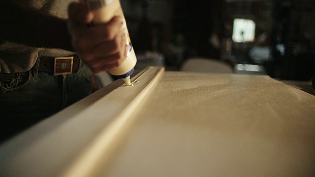 四十多岁的白人木匠用胶粘木头视频素材