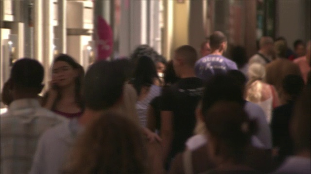 许多行人在穿过拥挤的马赛零售区时都用手机。视频下载