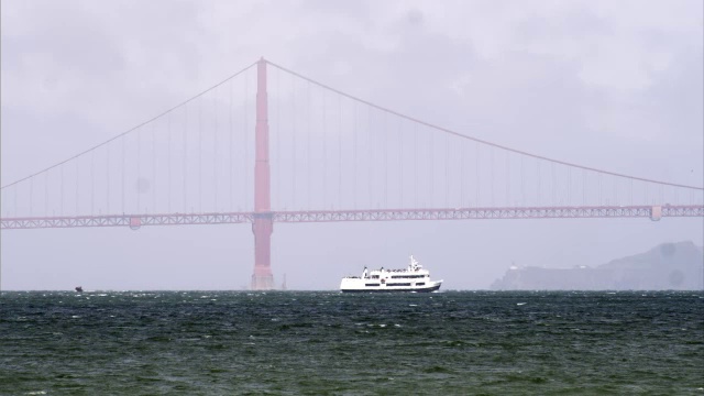 旧金山湾的渡轮与金门大桥后面的静态镜头。视频素材