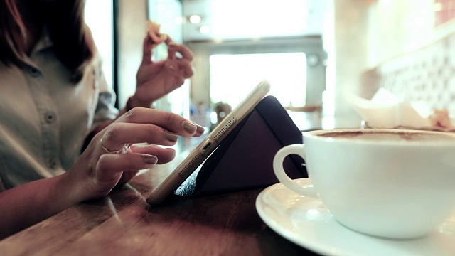 在咖啡店里用平板电脑的女人视频素材