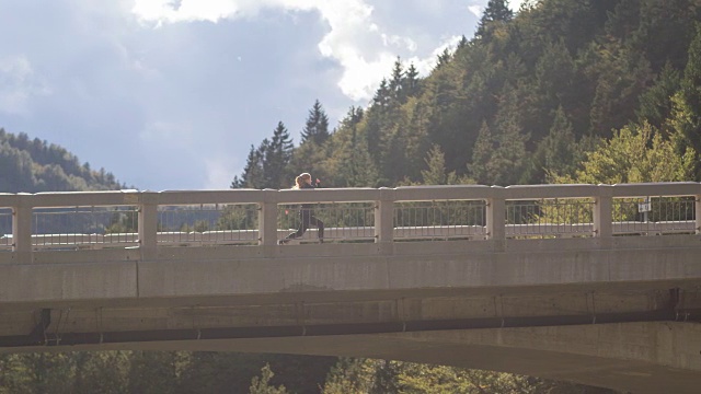 年轻女子在桥上跑步视频素材
