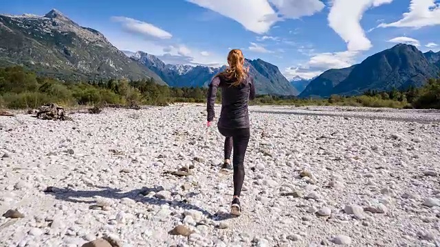 一个年轻女人在空河床上奔跑视频素材