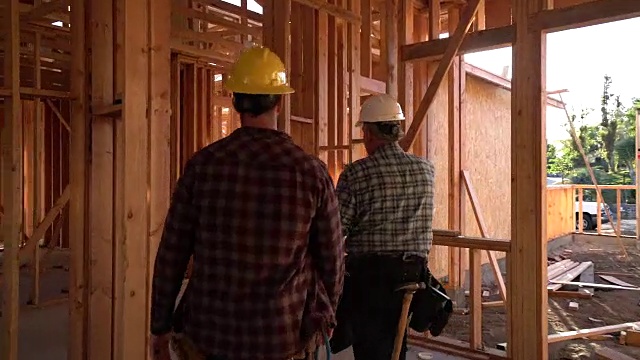 MS TS建筑商穿过一座在建的房子。视频素材