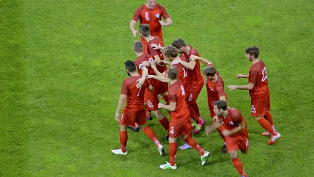 足球运动员在足球比赛中进球并和他的球队一起庆祝视频素材