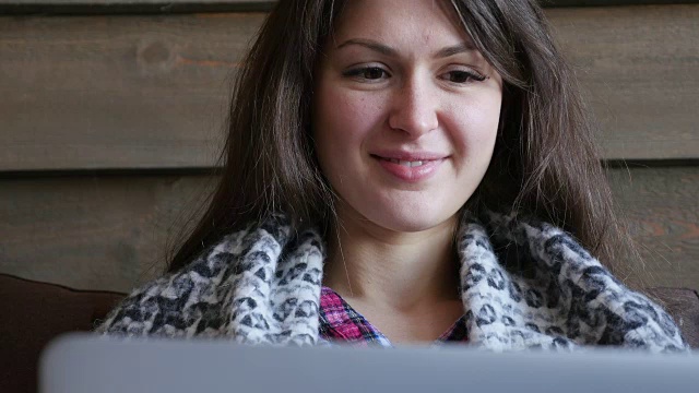 快乐的女人用手提电脑盖着毯子视频素材