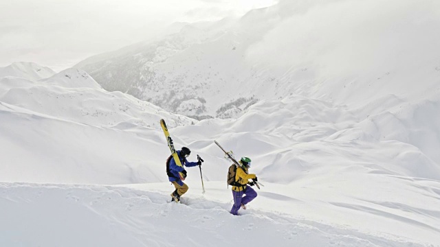 两个偏远地区的滑雪者正在穿越一座雪山视频素材