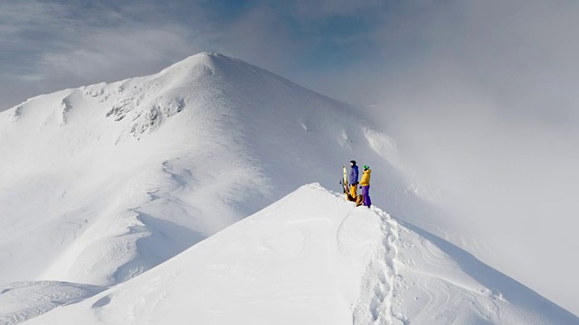 两个偏远地区的滑雪者站在积雪的山脊上视频素材