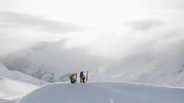 两个偏远地区的滑雪者在一座雪山上准备下山视频素材