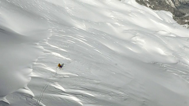 空中的野外滑雪者从阳光明媚的山坡上滑雪视频素材