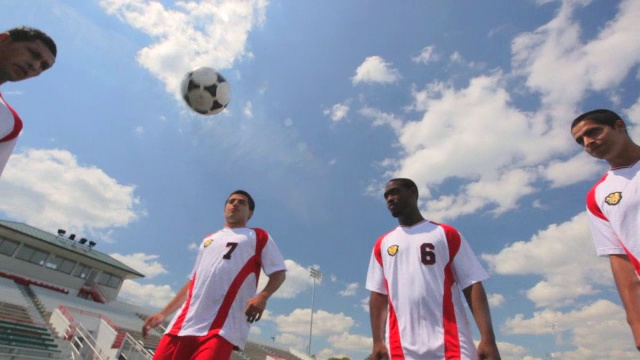 足球运动员站成一圈，互相踢球。视频素材