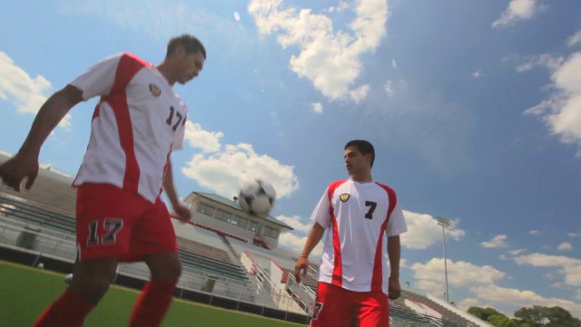 一组足球运动员站成一个圈，把球踢给对方。视频素材