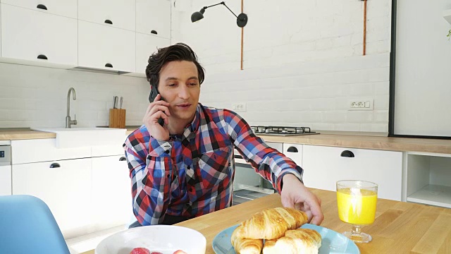 男人一边吃早餐一边打手机。视频素材