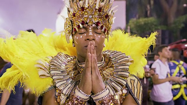 一名舞蹈演员在巴西里约热内卢狂欢节游行开始前祈祷视频下载