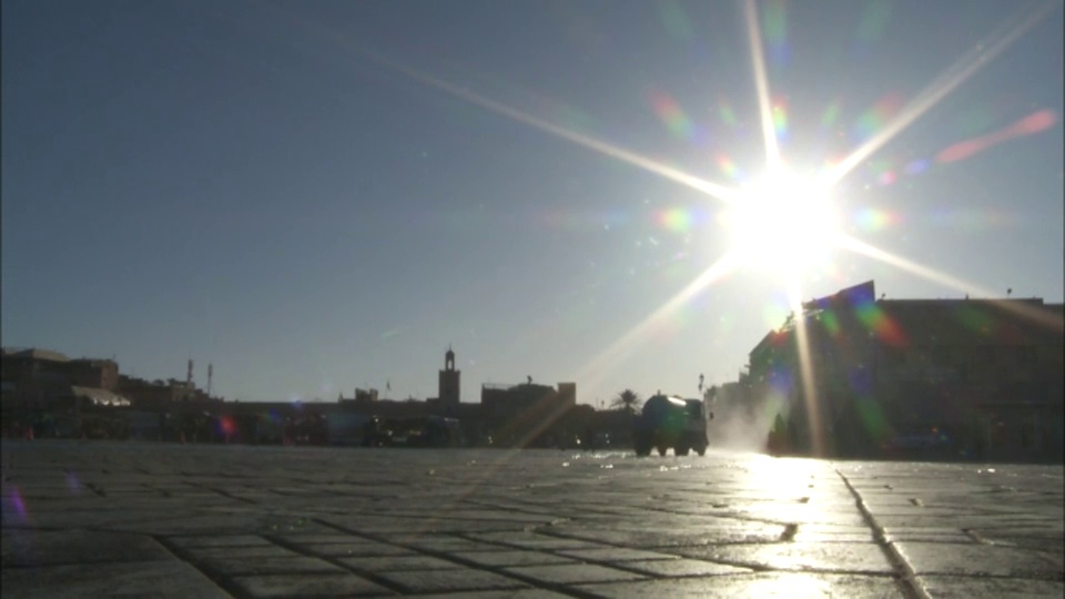 摩洛哥马拉喀什Jemaa El Fna市场附近，阳光照耀着一辆向街道喷洒水的卡车。视频素材