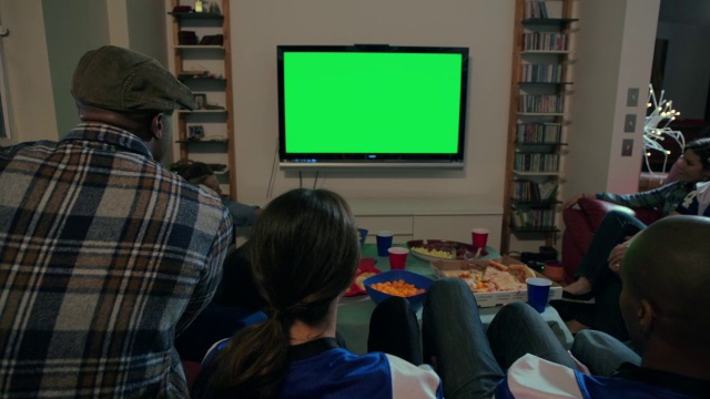 一群年轻的成年男性和女性一起庆祝在电视上观看体育运动视频素材