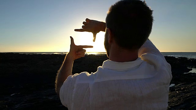 年轻人在海边休息，画面上是日落视频下载