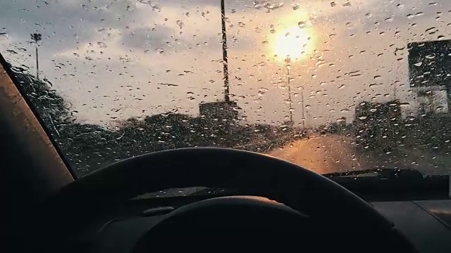 在日落的时候，沿着汽车的挡风玻璃跟踪雨点视频下载