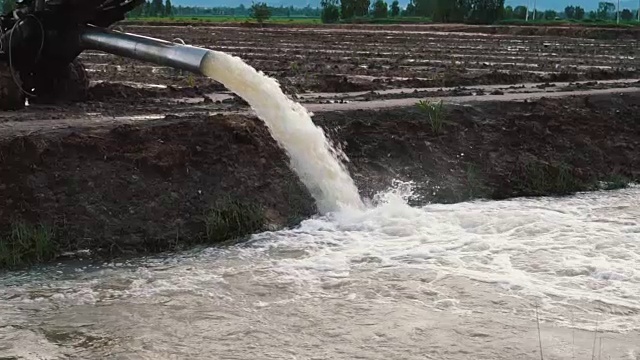 SLO MO pan down的一个水灌溉泵水到田地视频下载