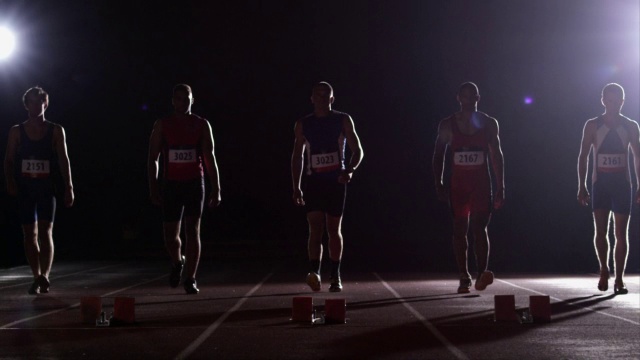 一群男运动员接近起跑线，准备开始比赛。视频素材
