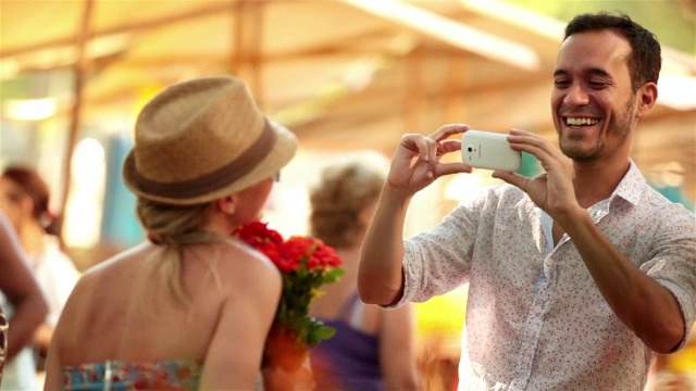 可爱的巴西女孩拿着一束花在智能手机上拍照视频素材