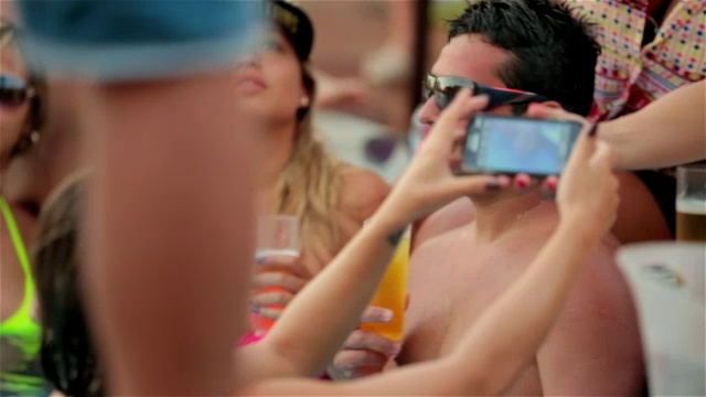 游泳池里的女孩用智能手机给朋友们合影视频下载