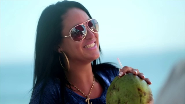 女孩和朋友们一起大笑，在伊帕内玛海滩木板路上喝着椰子视频素材