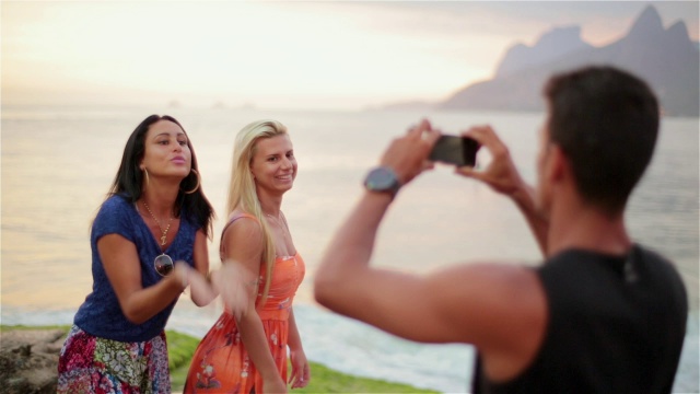 伊帕内玛海滩上，巴西女孩用智能手机飞吻拍照视频素材