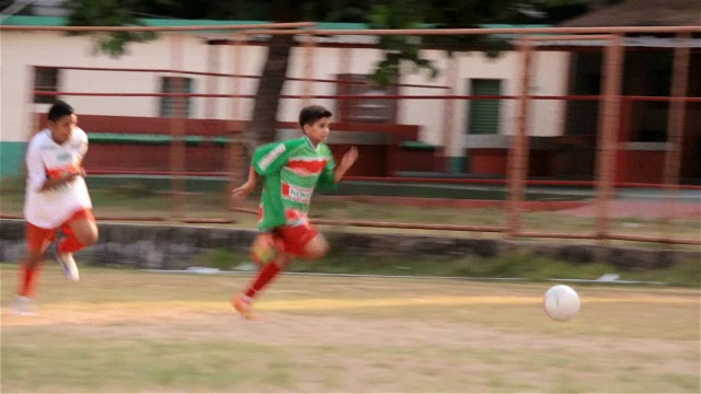 年轻的巴西足球运动员带球穿过对方的防守，寻找空位传球视频下载