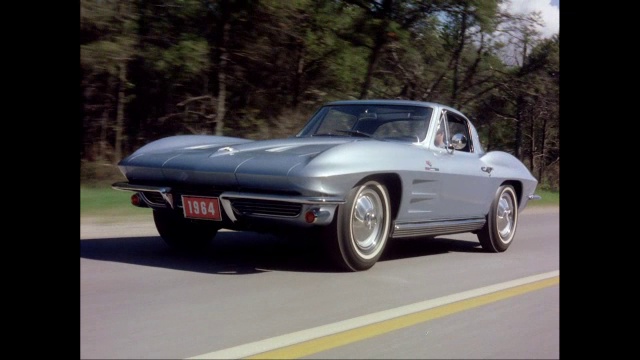 WS TS男子驾驶1964年雪佛兰Corvette汽车在街道上行驶/美国视频下载