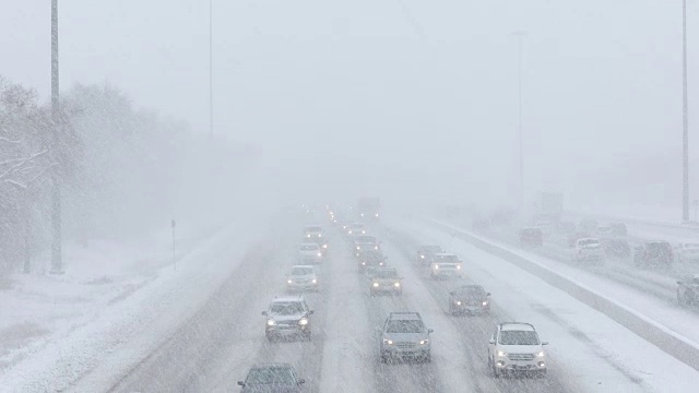 在积雪覆盖的道路上行驶的汽车视频下载