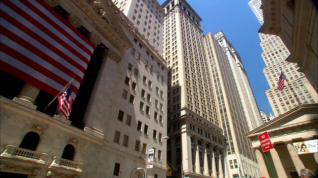 从华尔街大厦到纽约证券交易所的美国国旗的低角度宽镜头视频下载