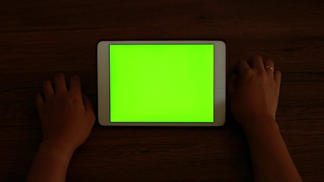 女人看绿色屏幕的平板电脑视频素材