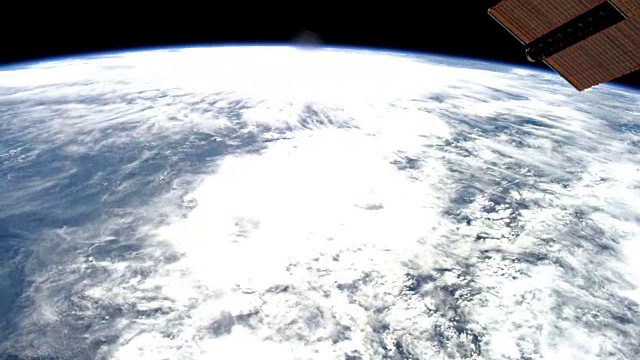 从国际空间站(ISS)靠近并慢慢离开地球。阳光反射在海面上的美丽色彩视频下载