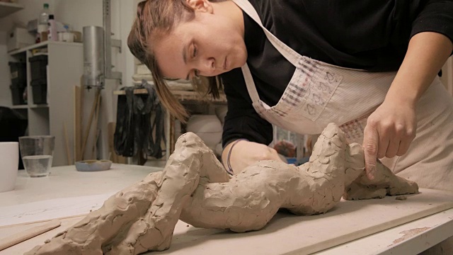 艺术工作室。正在做雕塑的年轻女子。视频下载
