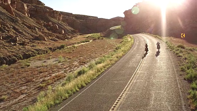 兩名男子騎著摩托車穿越沙漠公路，鳥瞰圖視頻素材