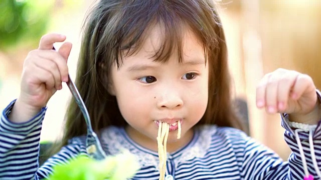 小女孩在吃美味的意大利面。视频下载