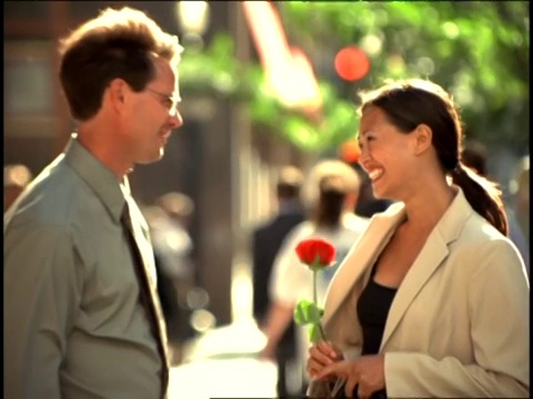 男人送给女人一朵红玫瑰后，女人表现得很害羞。视频素材