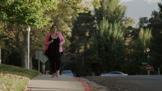 中等到近距离拍摄的女人疲惫后在人行道上慢跑/ Orem，犹他州，美国视频下载