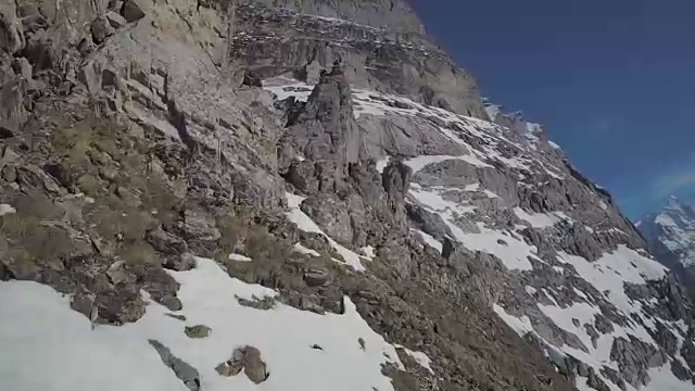 速度无人机视角的登山者攀登一个高山峰的顶峰视频下载
