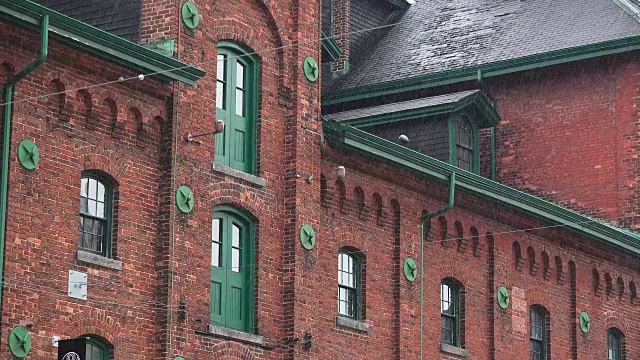 多伦多，加拿大:细节酒厂地区在一个雨天。雨落在国家历史遗址的旧建筑和街道上视频下载